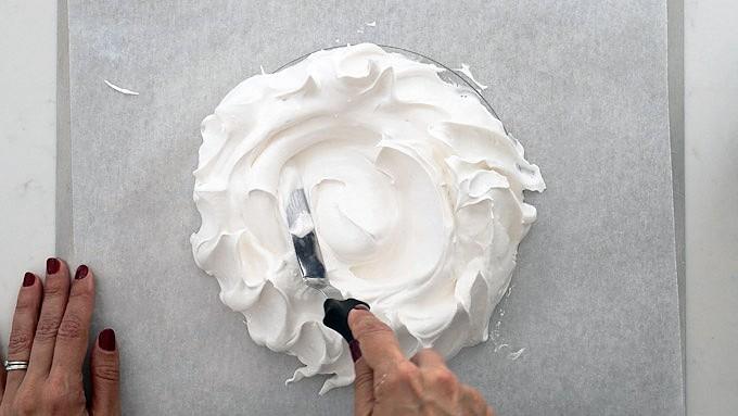 Shaping a pavlova on a baking tray with an offset spatula