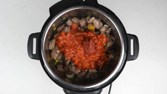 Making goulash in an Instant Pot with the tomatoes layered on top