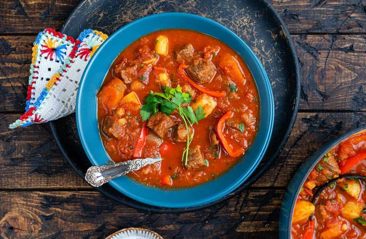 A bowl of Hungarian beef goulash topped with fresh parsley