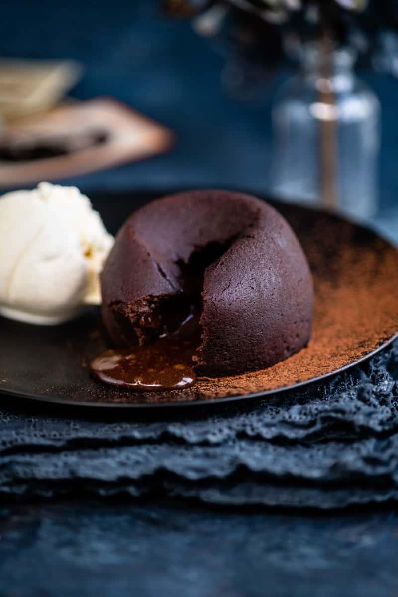 Chocolate lava cake split open to show the molten core served with ice cream