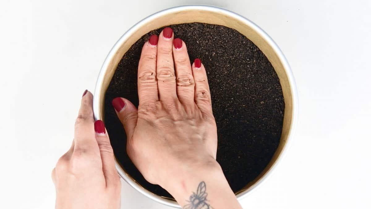 Pressing the crust into a cheesecake pan