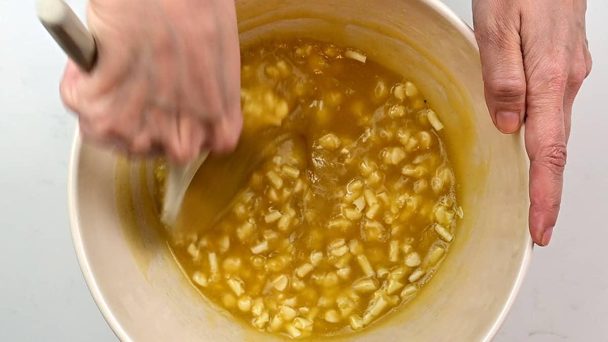 Folding chocolate chips into blondie batter in a mixing bowl