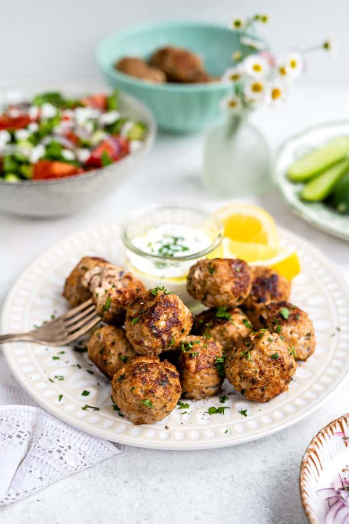 Plate of Greek meatballs (keftedes) served with Tzatziki and Greek salad