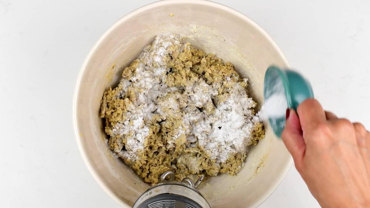 adding salt and xantham gum to low carb bread dough in a bowl