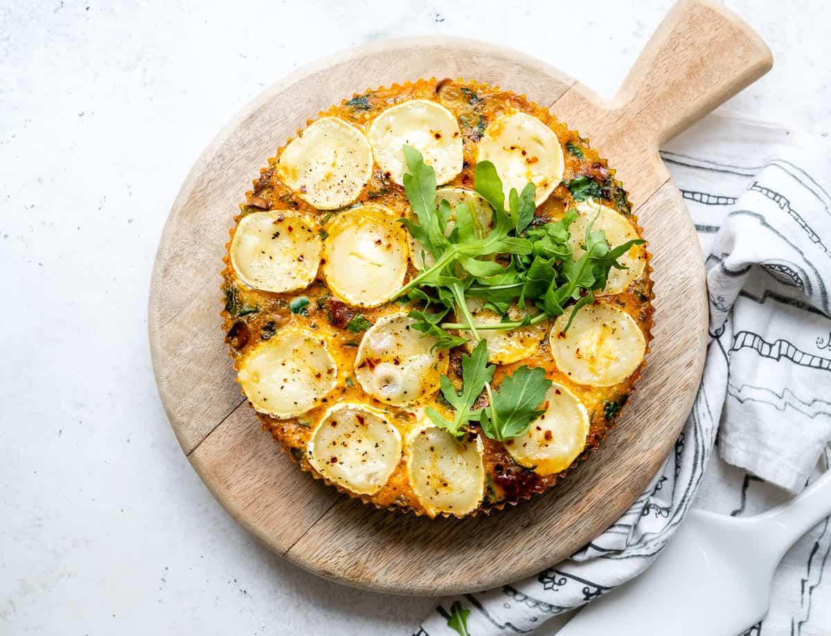Slow cooker quiche with chorizo and goat's cheese on a wooden board