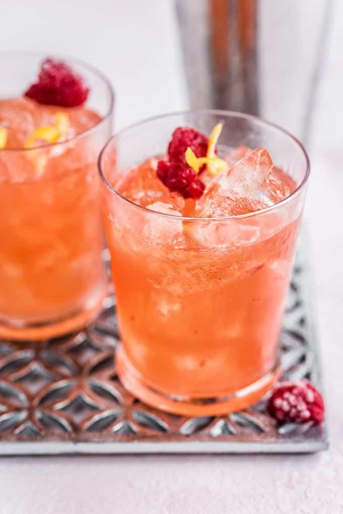 Knickerbocker cocktail served in rocks glasses over ice and garnished with raspberries
