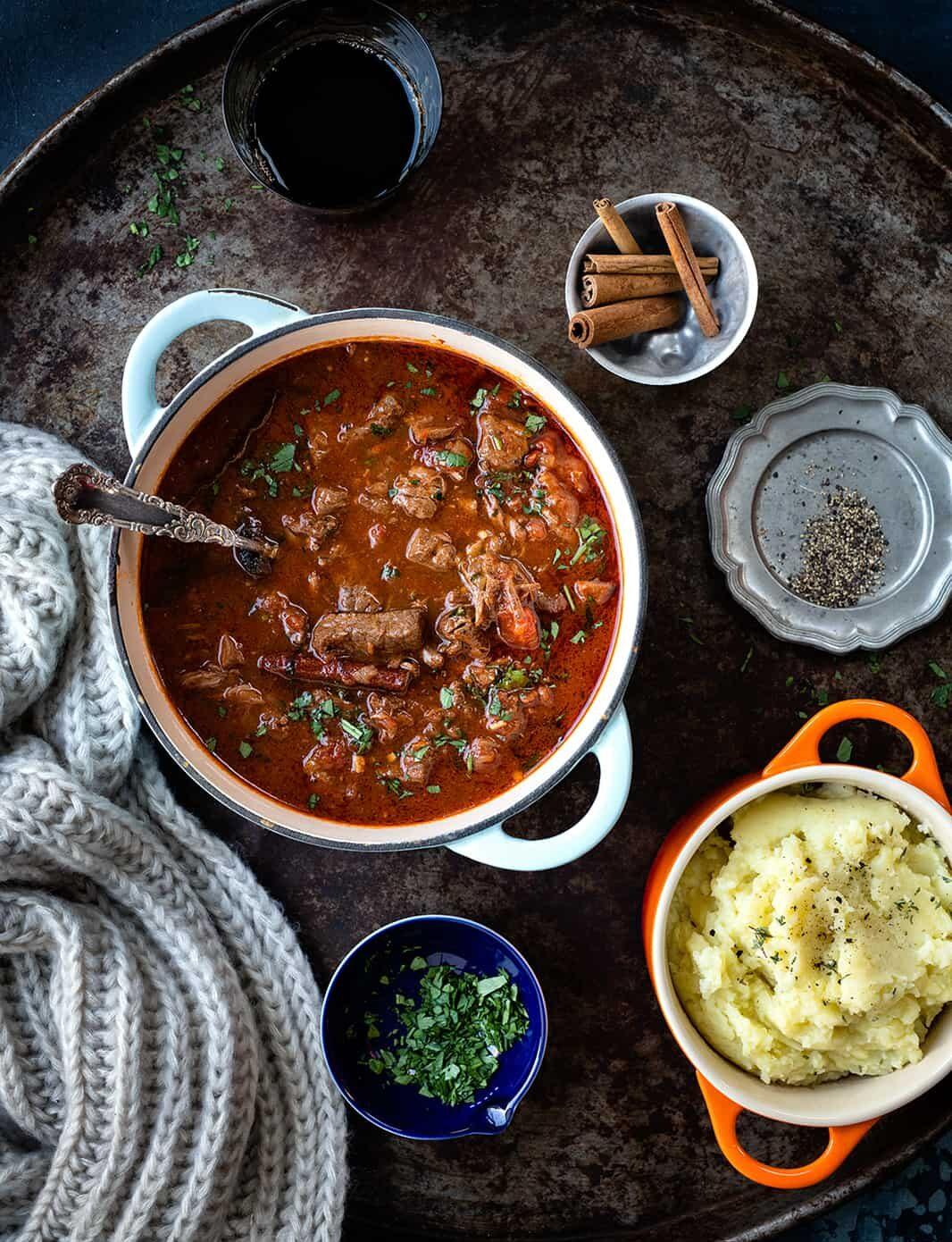 Kokinisto – Greek beef stew in a clay pot with mashed potatoes on the side