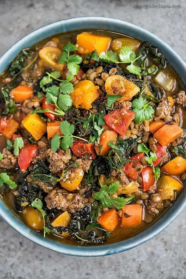Close up on a bowl of lamb and lentil stew garnished with coriander