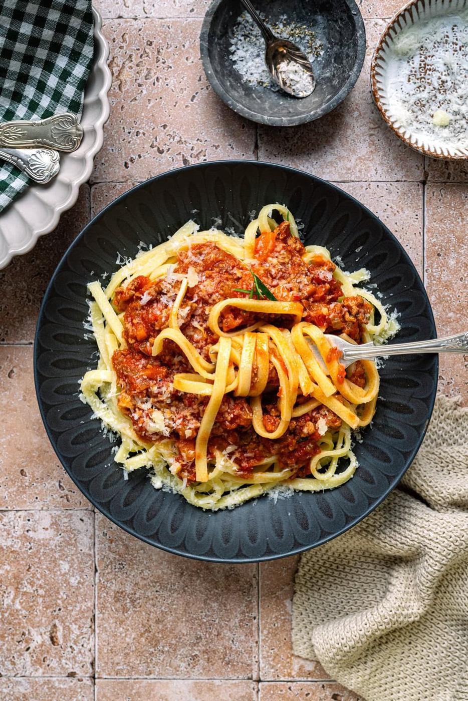 Pasta with lamb ragu sauce in a black pasta bowl