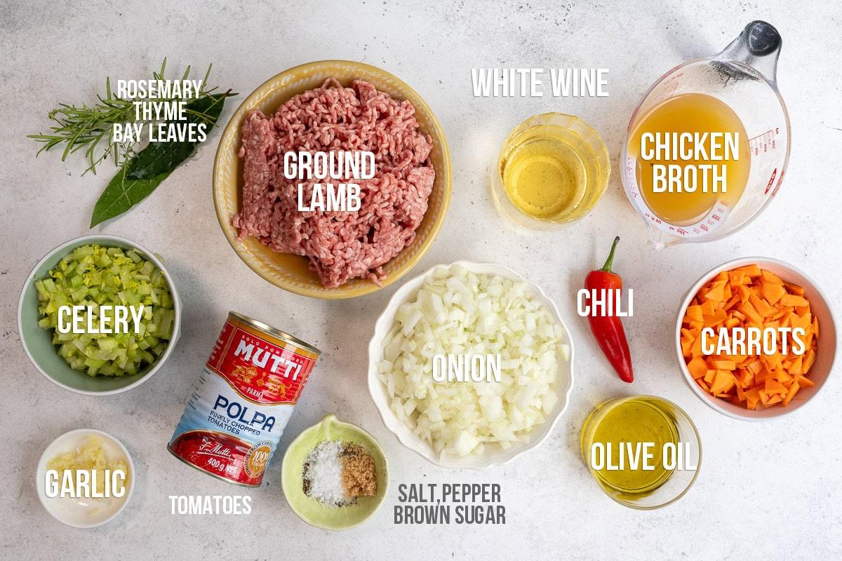 Ingredients for lamb ragu with labels on a white countertop