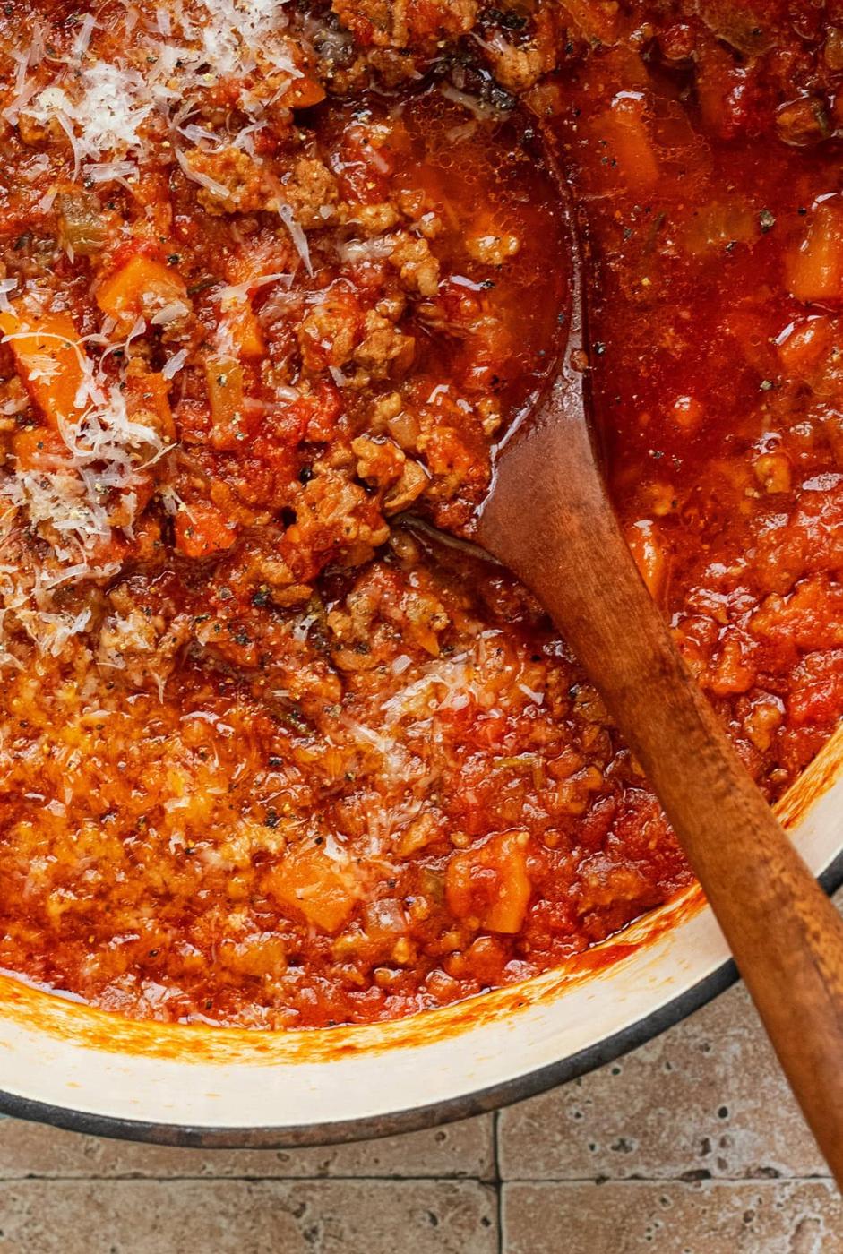 close up on lamb ragu sauce, wooden spoon in the pot