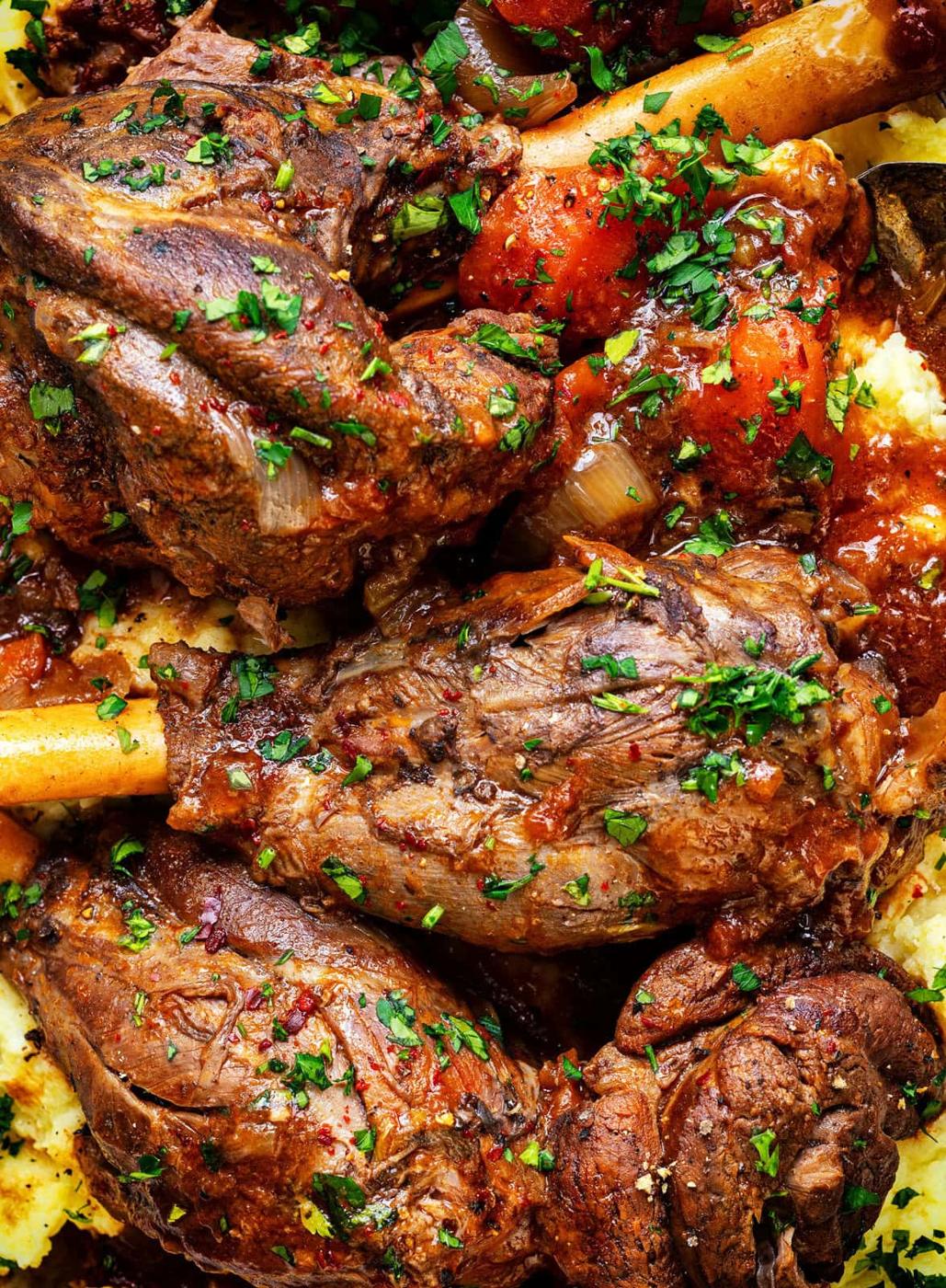 Tender slow cooked Greek lamb shanks in a tomato and red wine sauce, close up