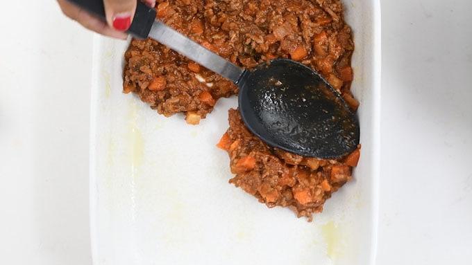 Assembling meat lasagna in an ovenproof dish