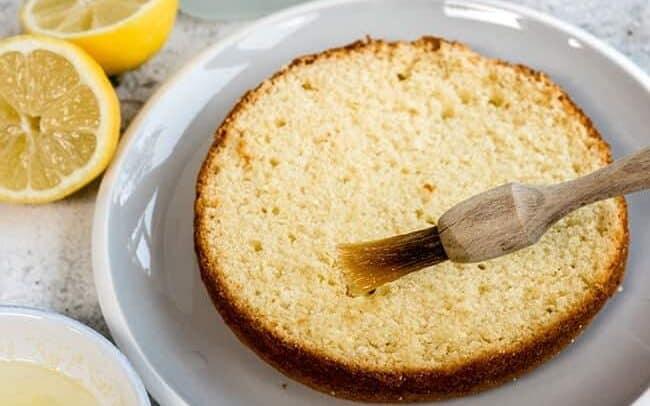 brushing lemon cake with syrup