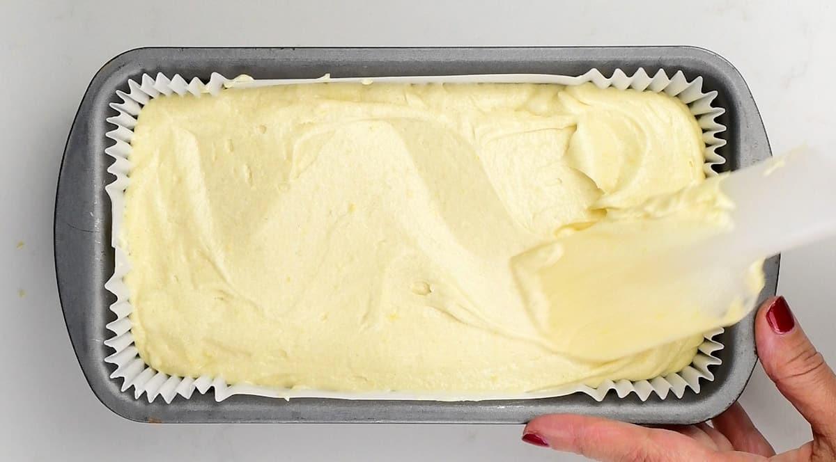 Levelling cake batter in a loaf tin with a spatula