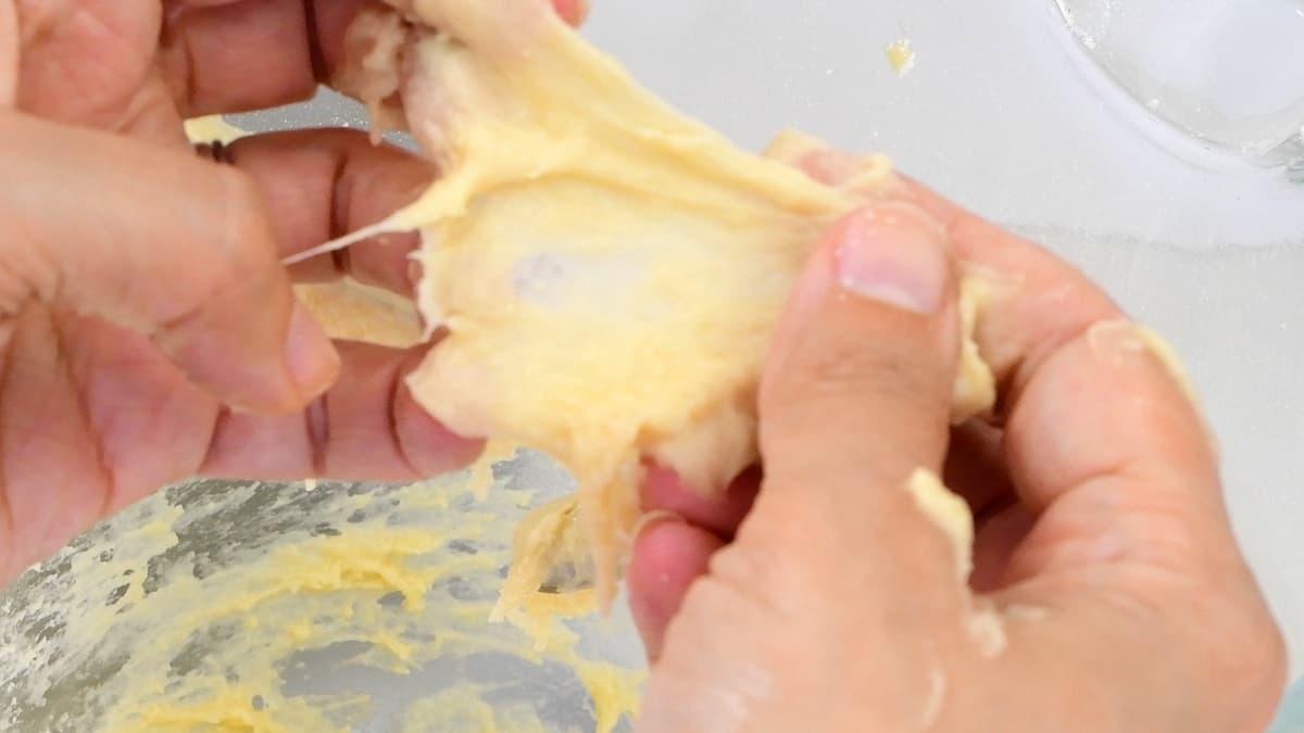 stretching dough between fingers to check whether it is ready