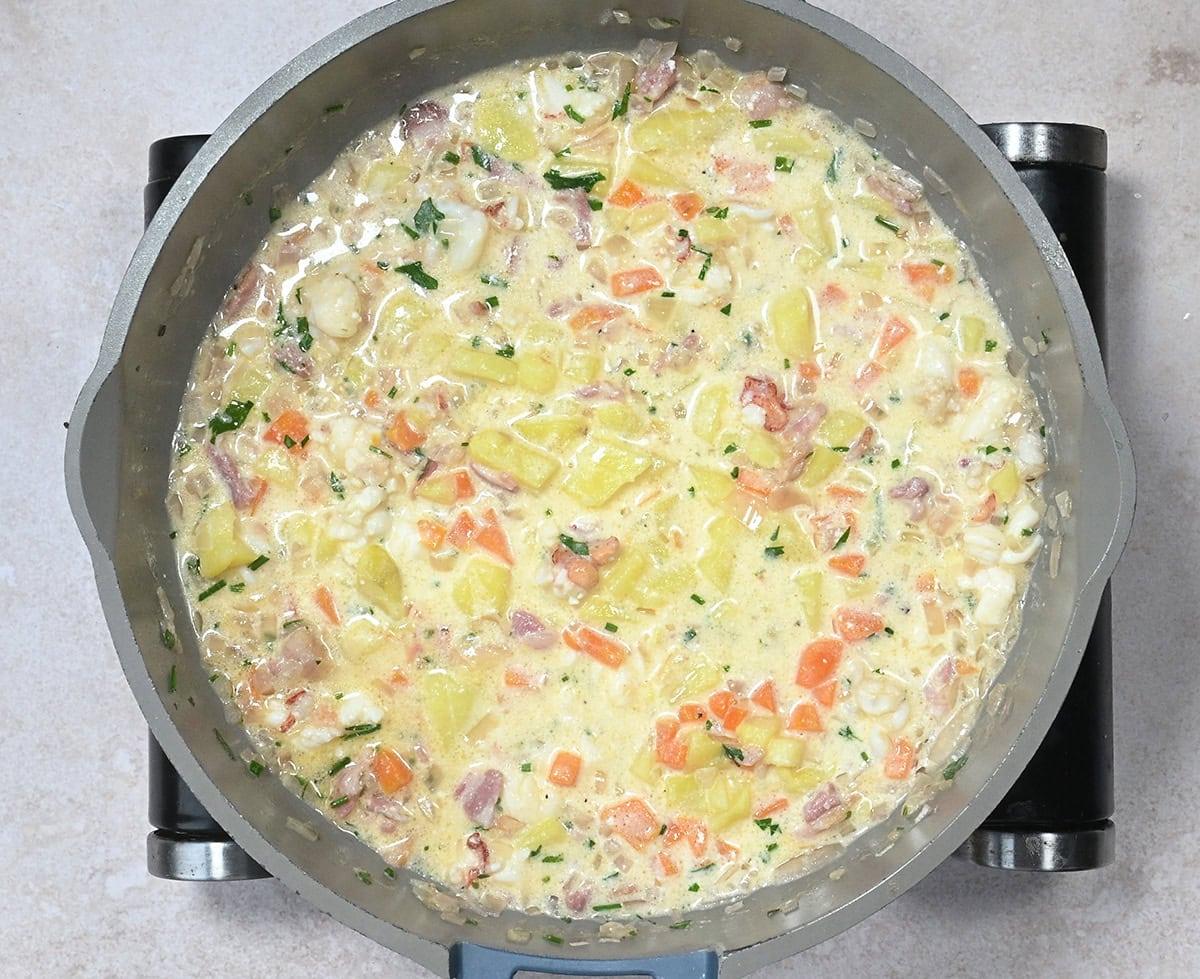 creamy lobster pot pie filling in a skillet