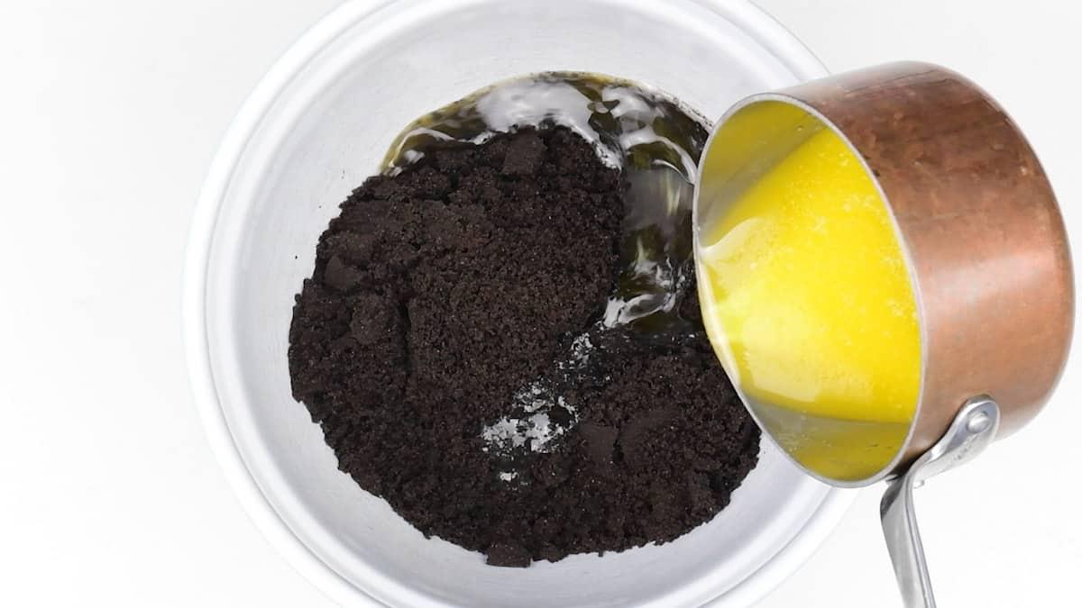 mixing cookie crumbs and melted butter in a bowl