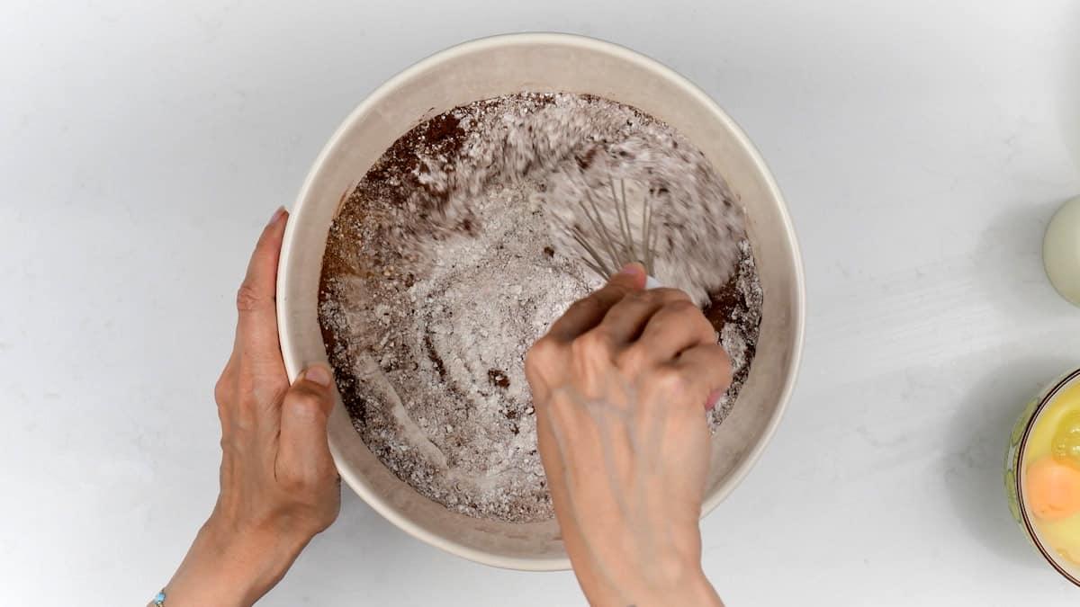 stirring ingredients for cake in a mixing bowl