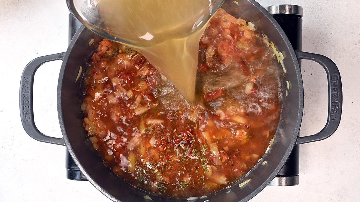 adding broth to dutch oven for soup