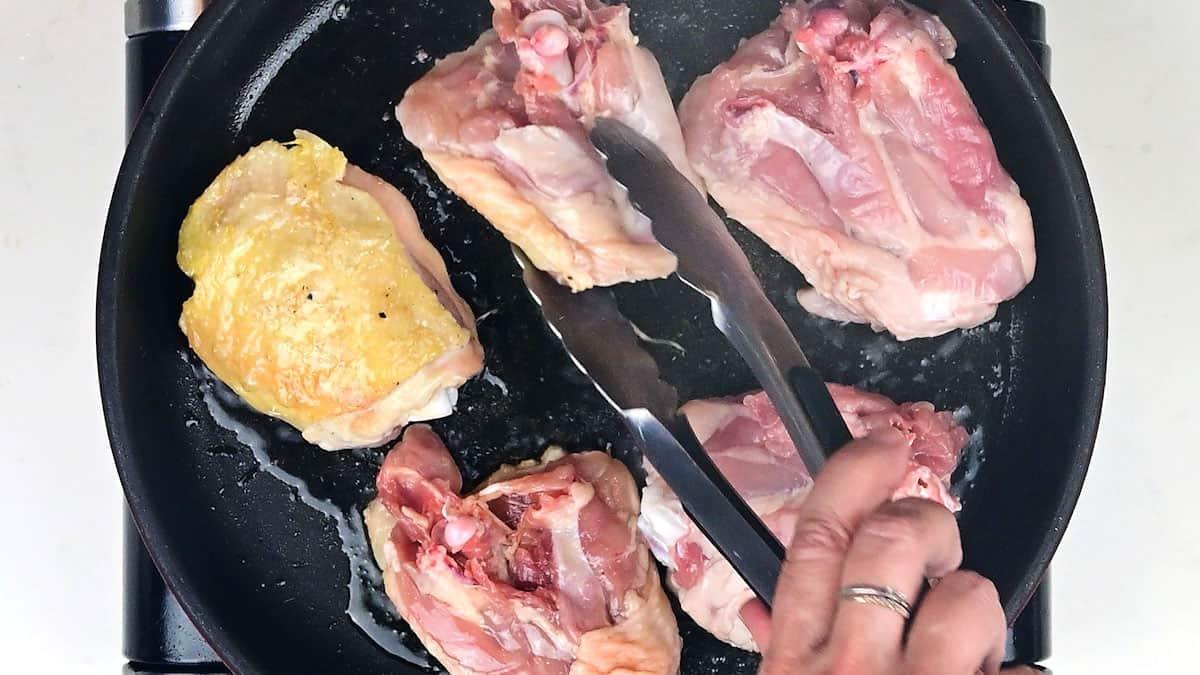 searing chicken thighs in a skillet