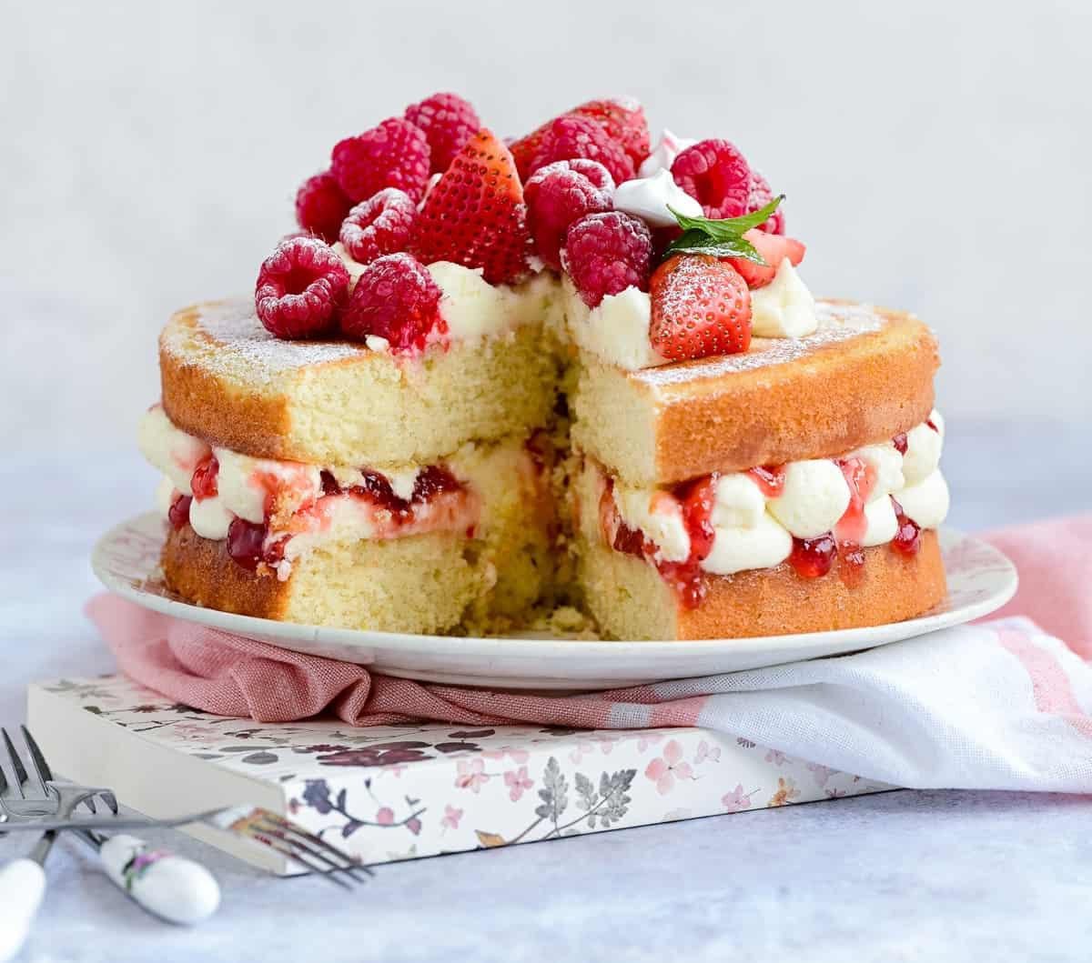 Victoria Sponge Cake with slice cut out on a plate