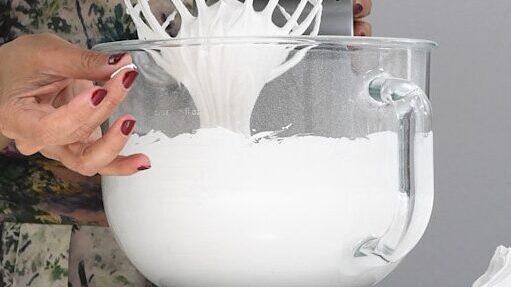 Checking the sugar has fully dissolved in the meringue by rubbing it between two fingers.