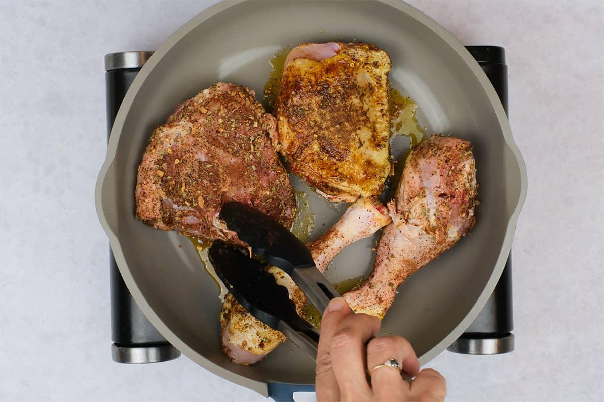 searing chicken thighs and drumsticks in a skillet