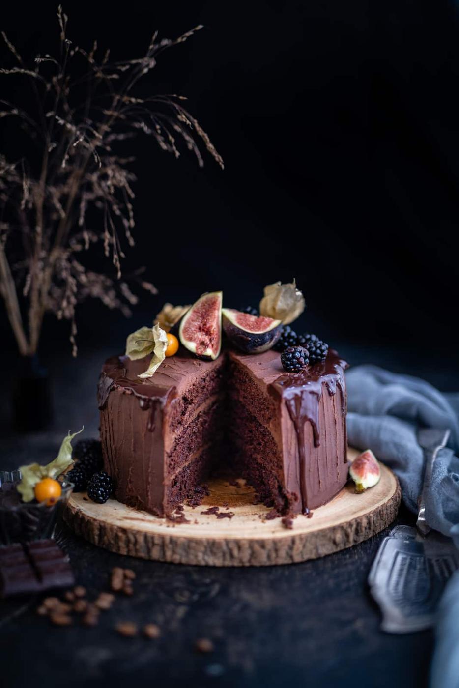 Chocolate cake decorated with fruit with a slice take out