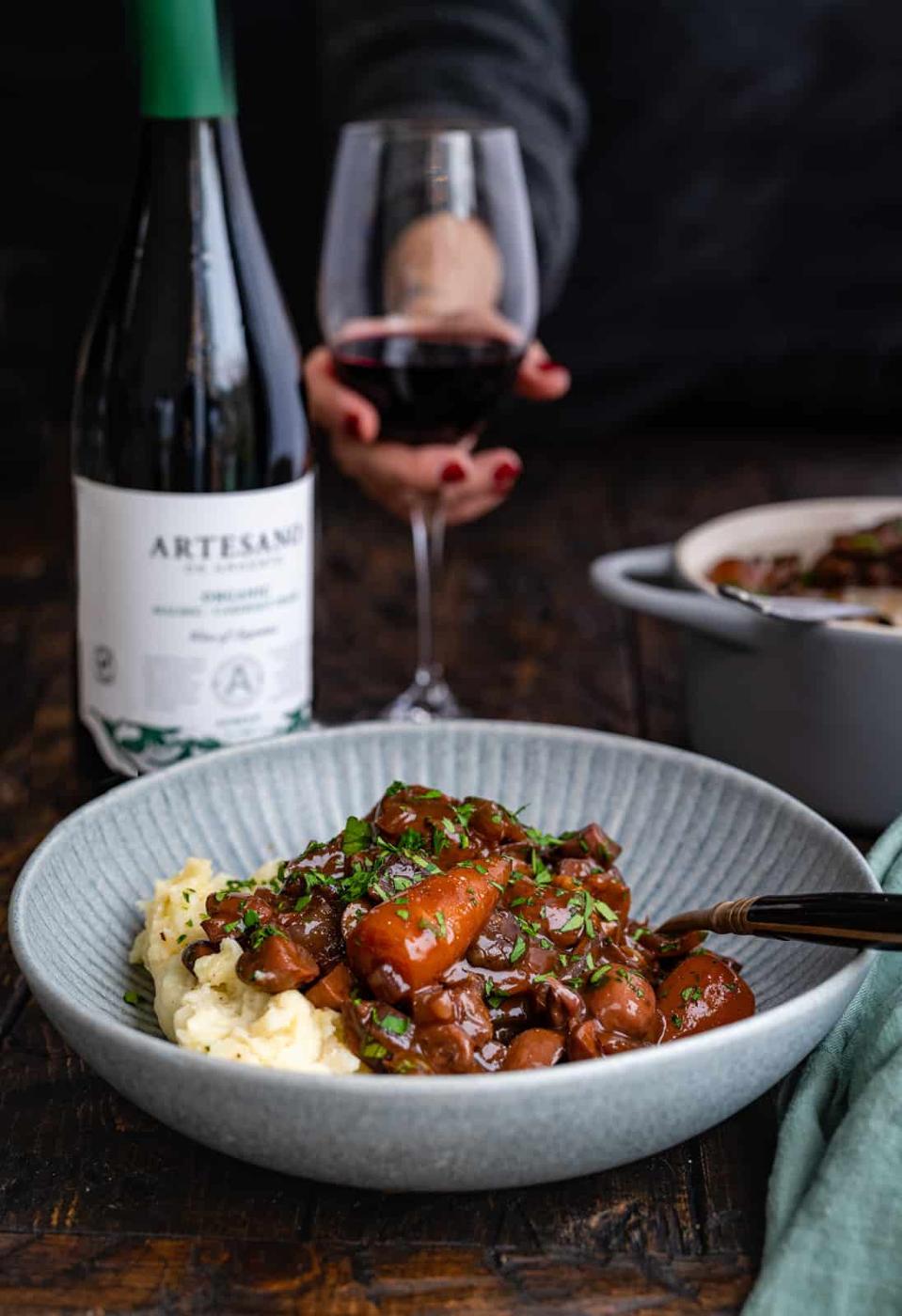 Serving of mushroom bourguignon with red wine on the side