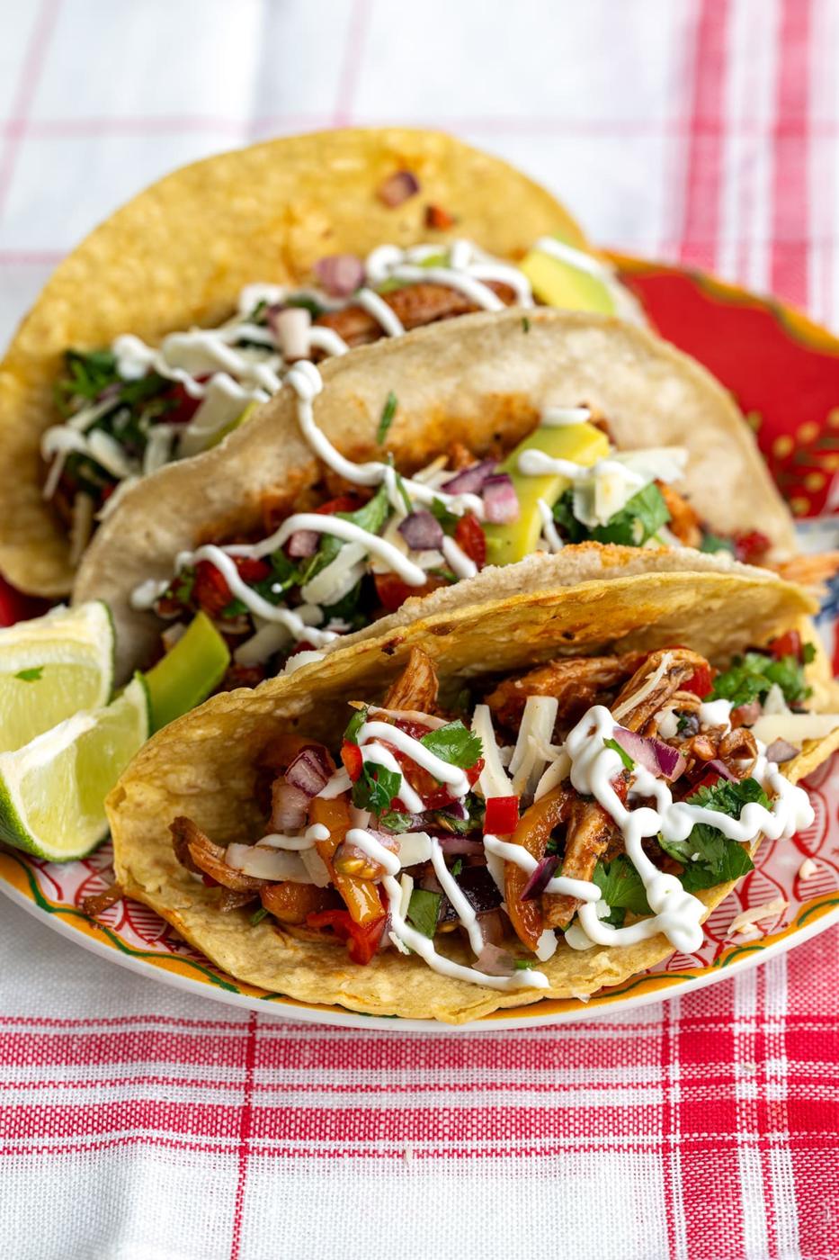 three filled air fryer chicken tacos with pico de gallo and sour cream