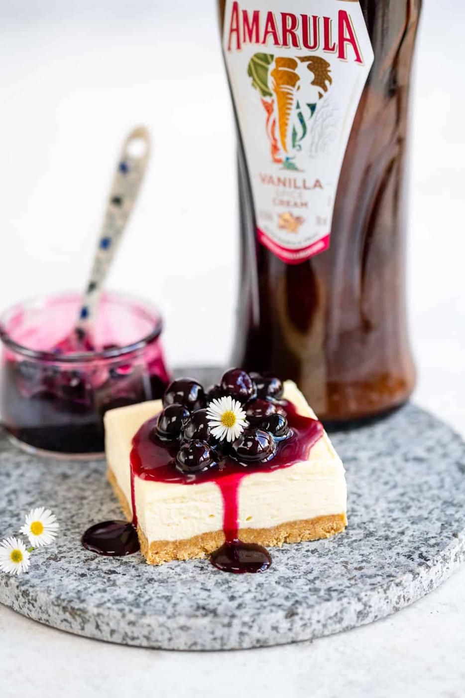 Vanilla cheesecake bar topped with blueberry compote on a marble board
