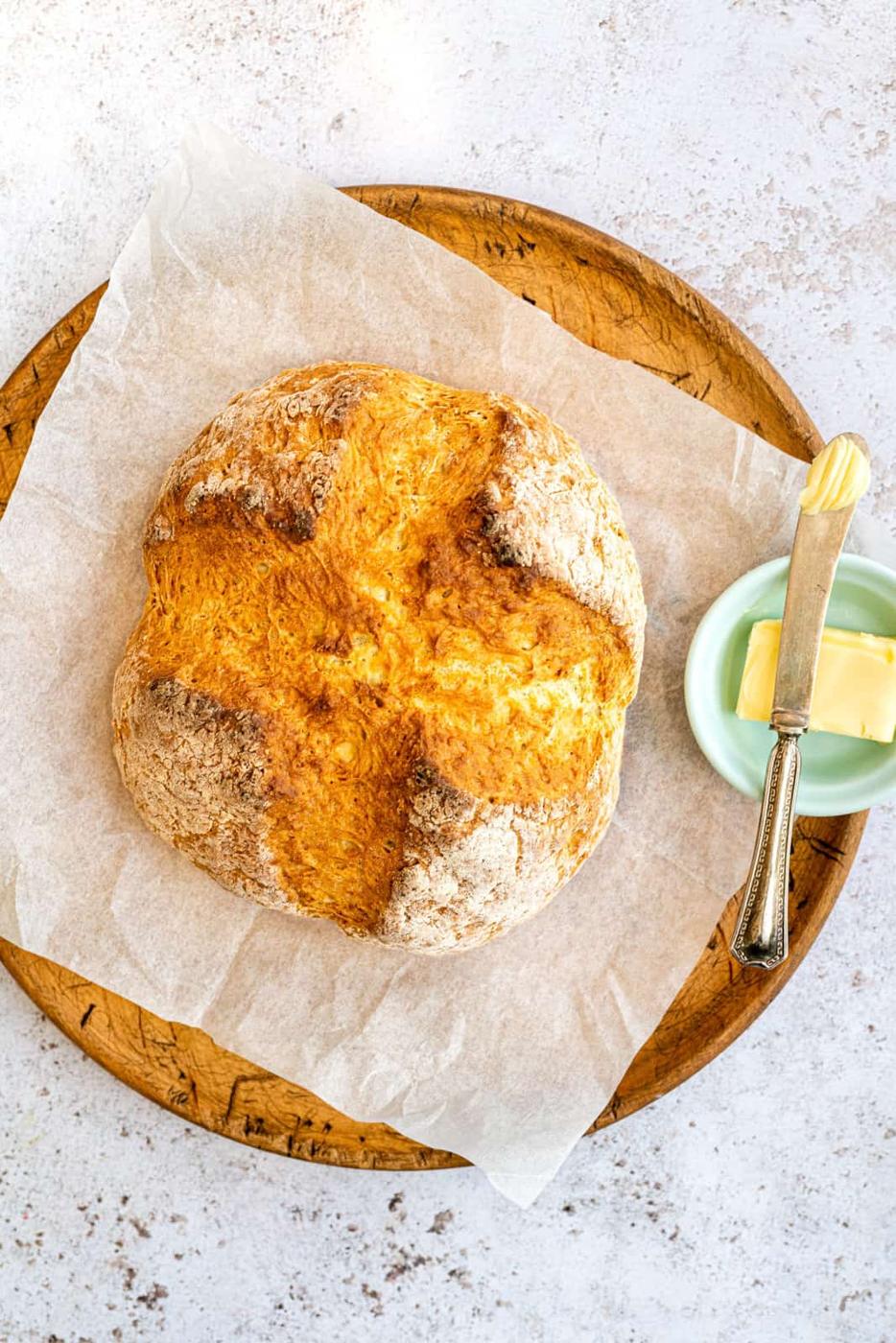 No yeast crusty bread on a wood board with butter on the side