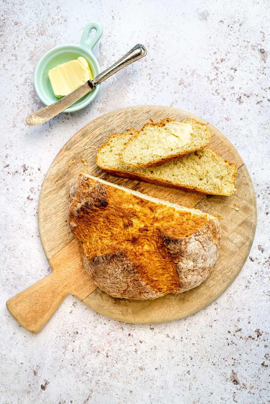 No yeast soda bread on a round bread board with slices cut out