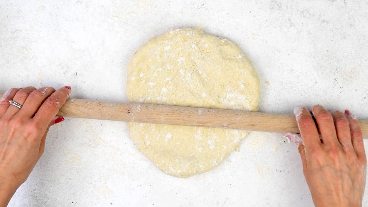 rolling out pizza dough with rolling pin