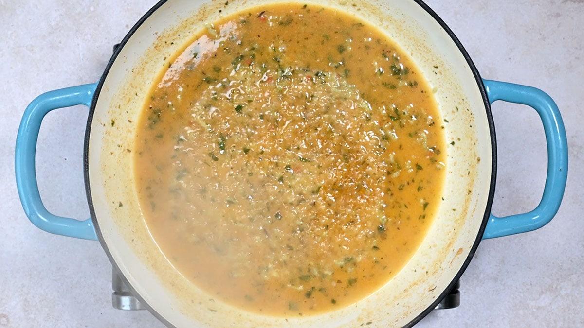 white wine, lemon juice, fish stock simmering in a skillet