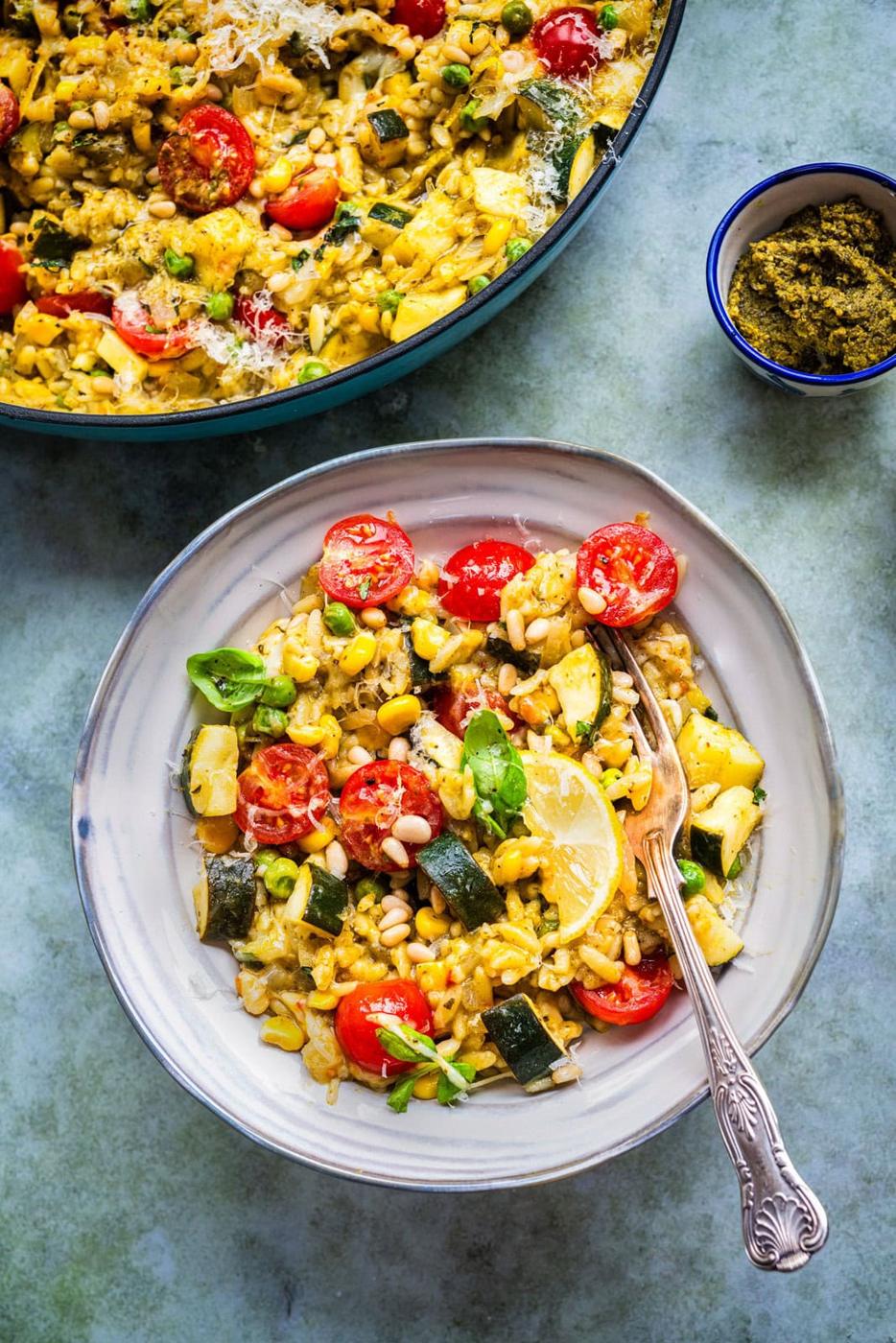 bowl serving of colorful pesto orzo with seasonal vegetables