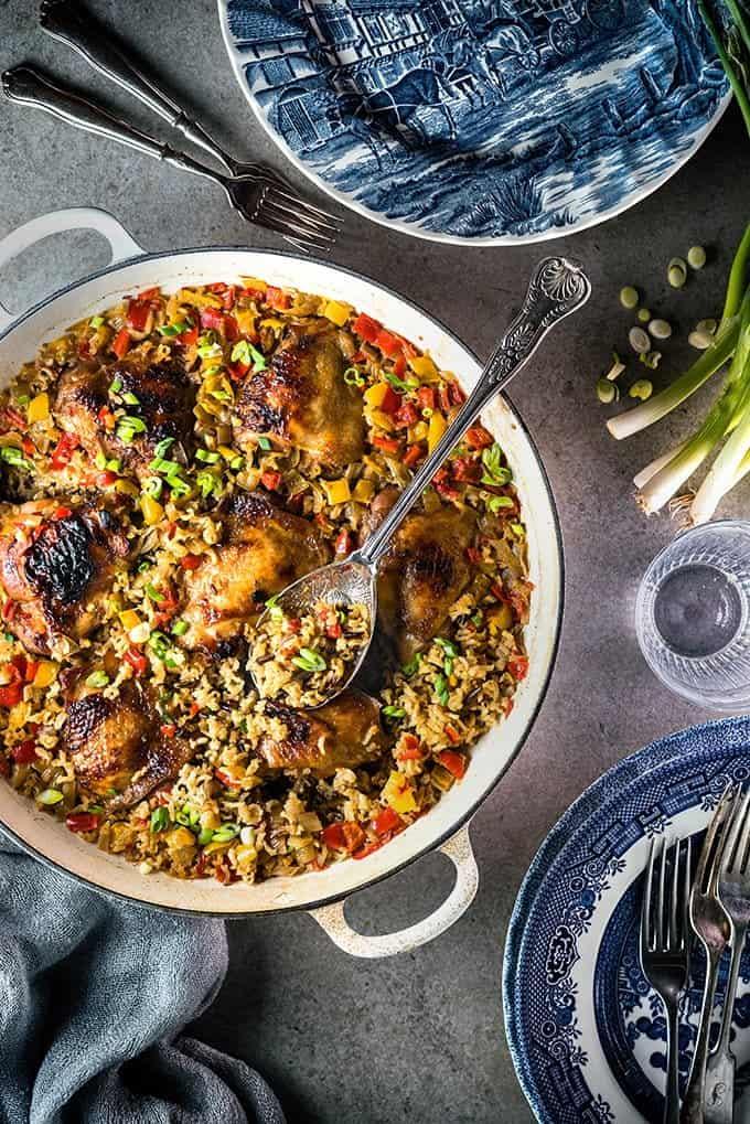 Overhead shot of chicken and rice dish cooked in a shallop cast iron casserole garnished with sliced green onions