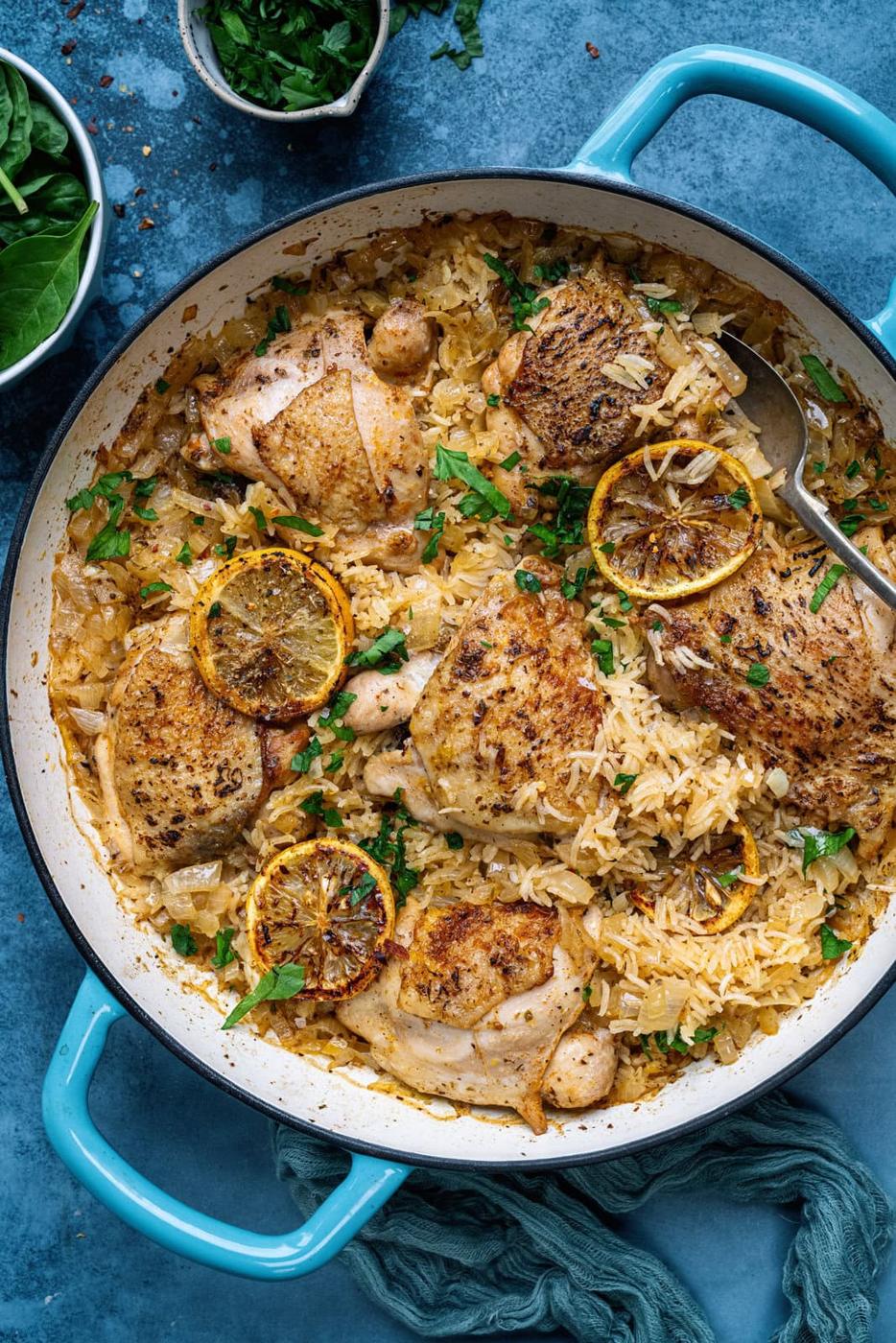 Overhead view of one pot Greek chicken and lemon rice against a blue backdrop