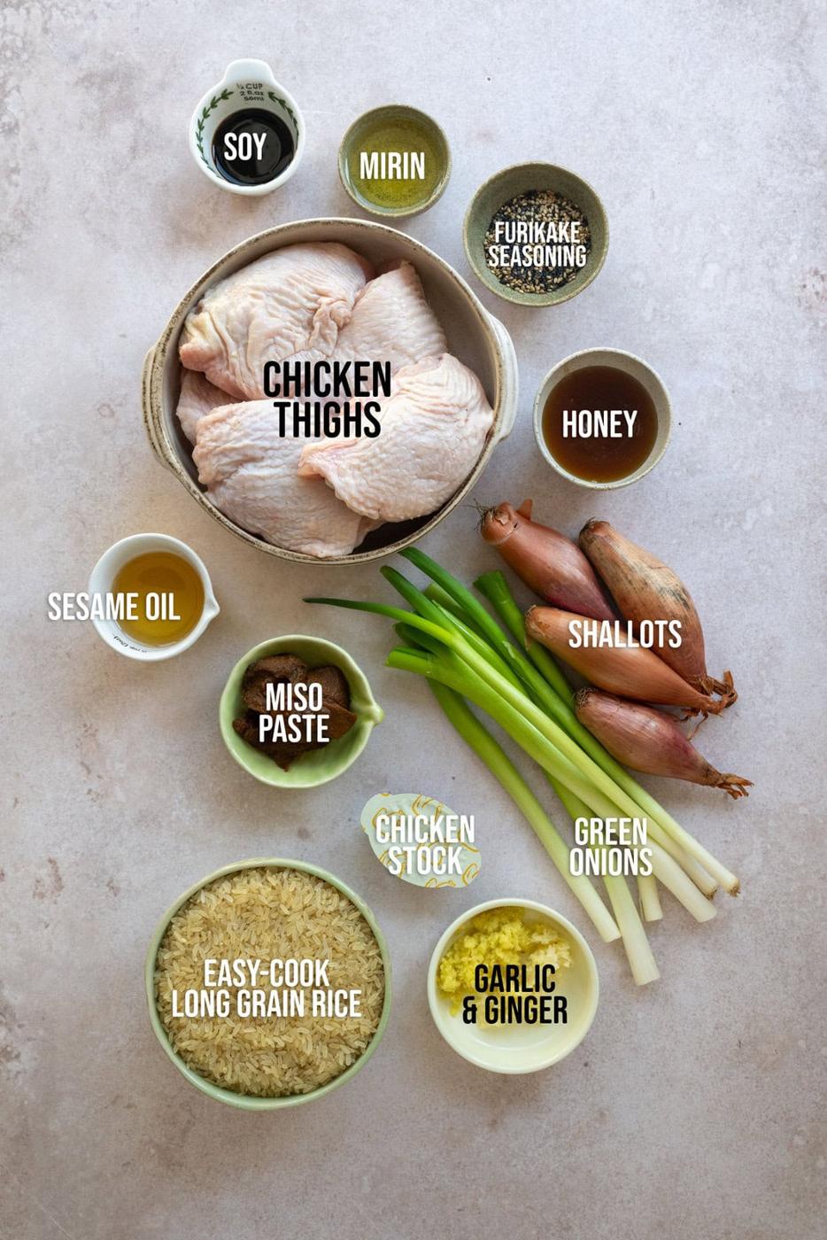 A top-down view of labeled ingredients for a chicken dish, including chicken thighs, soy, mirin, furikake seasoning, honey, shallots, green onions, garlic & ginger, chicken stock, miso paste, sesame oil, and long grain rice.