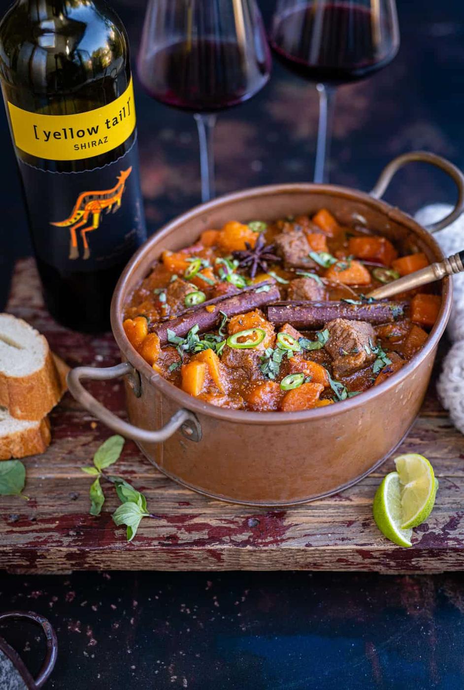 Pot of Vietnamese Beef stew with glasses of red wine