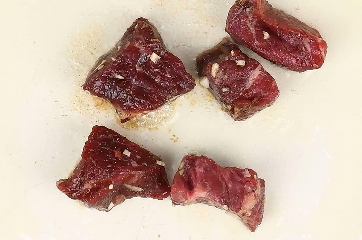 Browning beef in a hot casserole dish to make beef stew