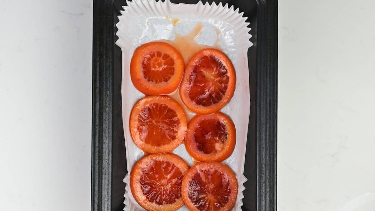 Loaf Cake Tin lined with cake liner and cooked orange slices to make upside down orange cake