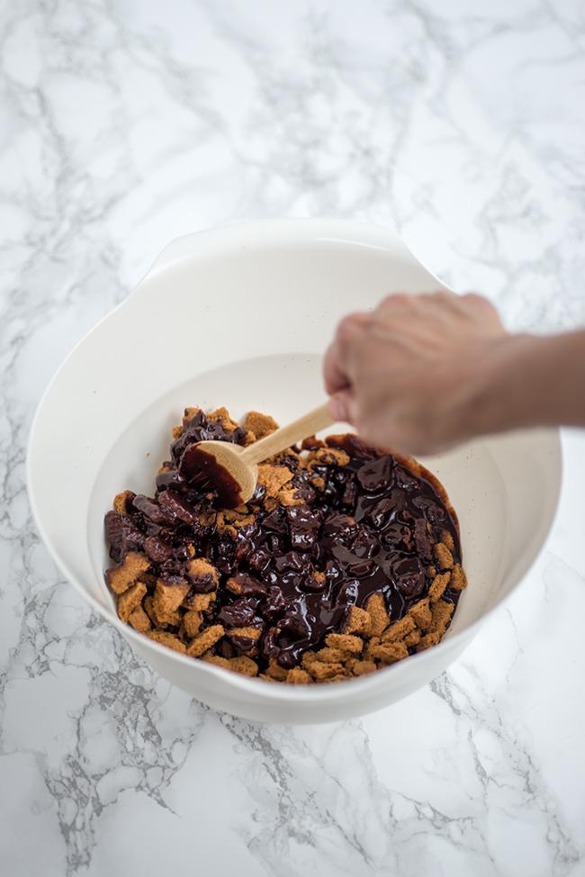 mixing melted chocolate and biscuits together in a bowl
