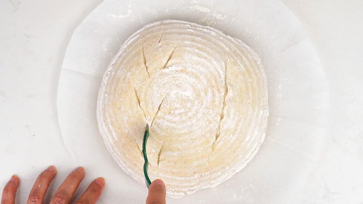 Scoring a sourdough loaf using a lame