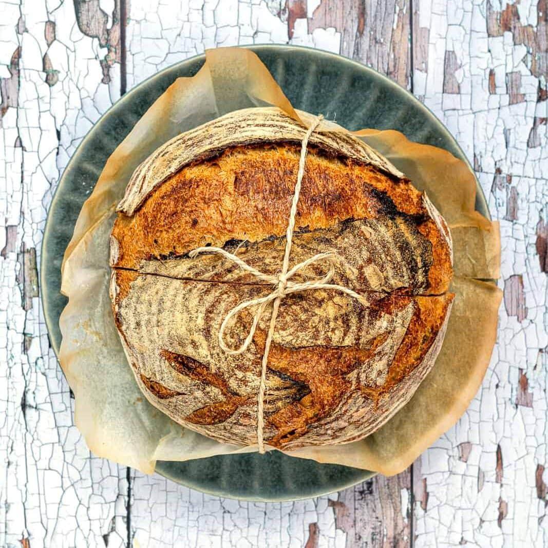 Overhead view of easy overnight sourdough bread tied with string on a plate