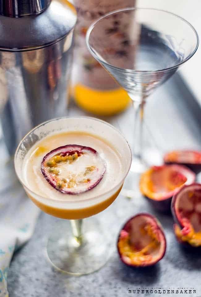 Passionfruit martini in a coupe glass on a metal tray with passion fruit on the side