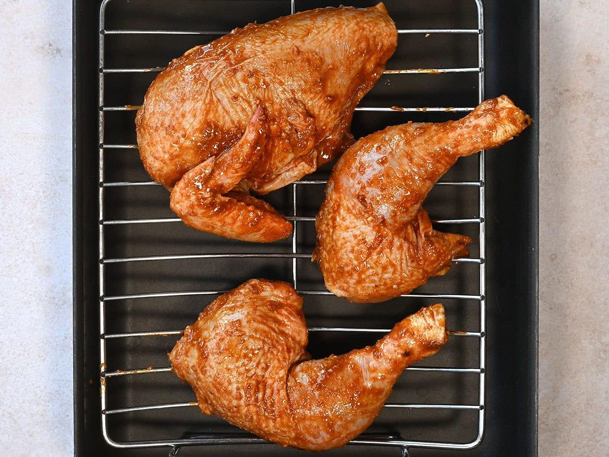 chicken placed on a rack over a roasting tray