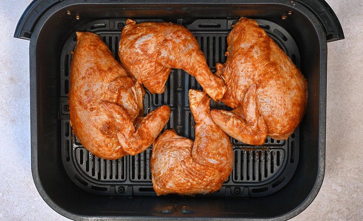 marinated Peruvian chicken in the basket of an air fryer