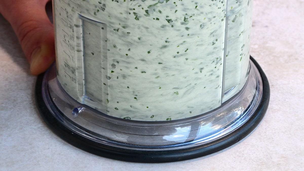 blending green sauce in a mini chopper